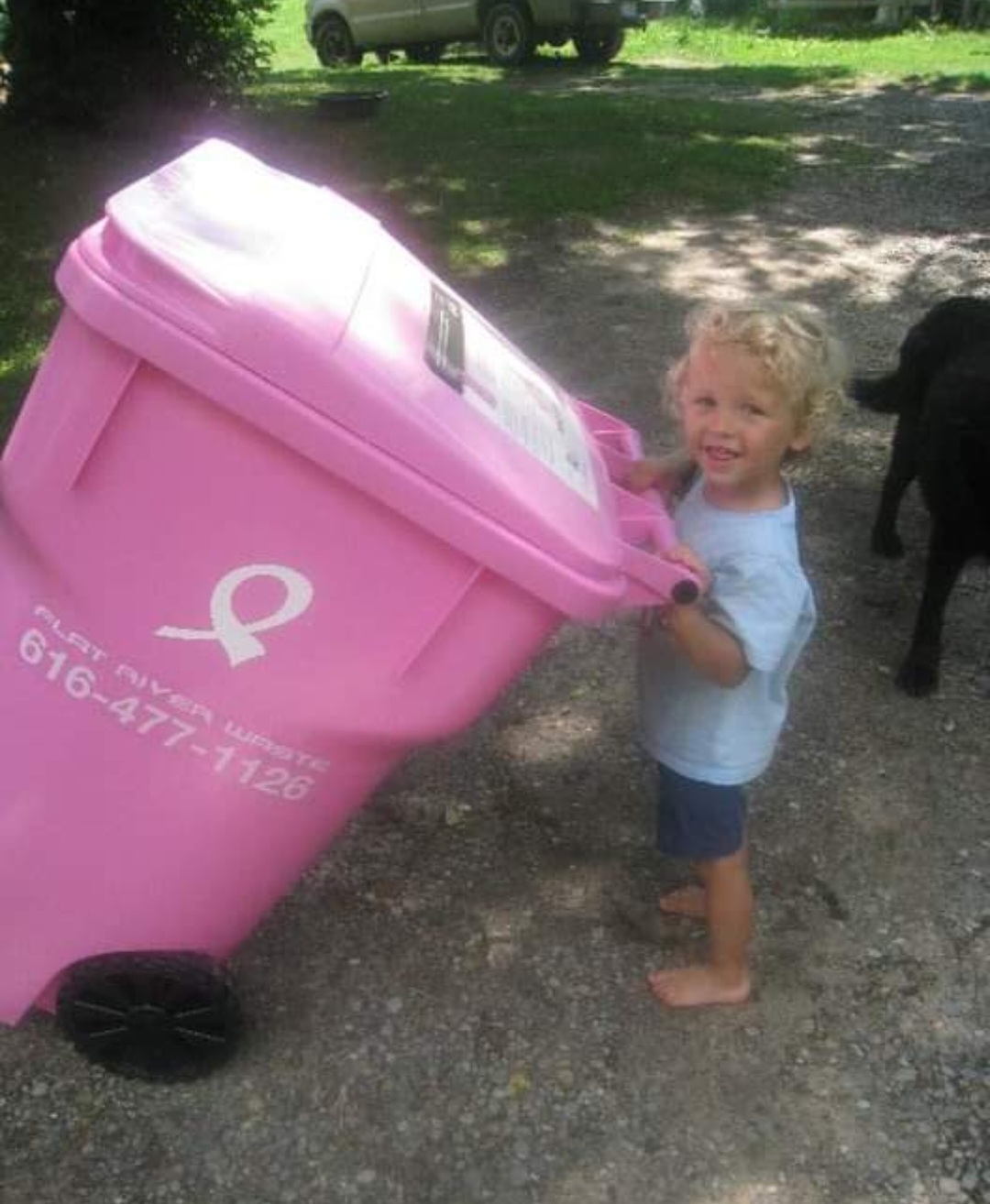 little boy pushing garbage can